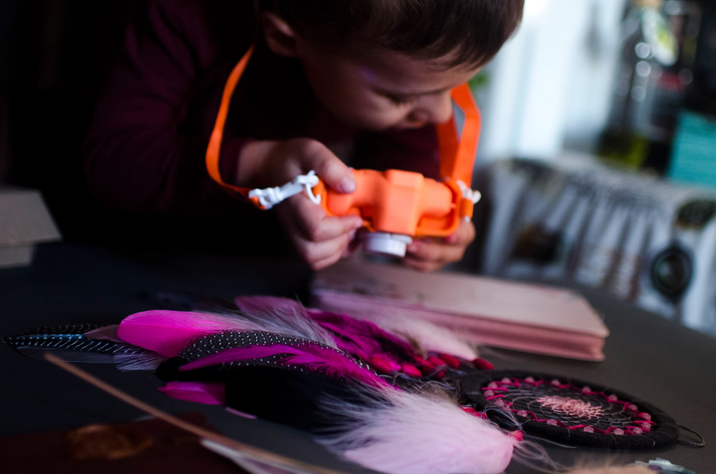 Handmade dreamcatcher in vibrant pink and black with bold feathers and woven web. Striking contrast for expressive, edgy spaces.