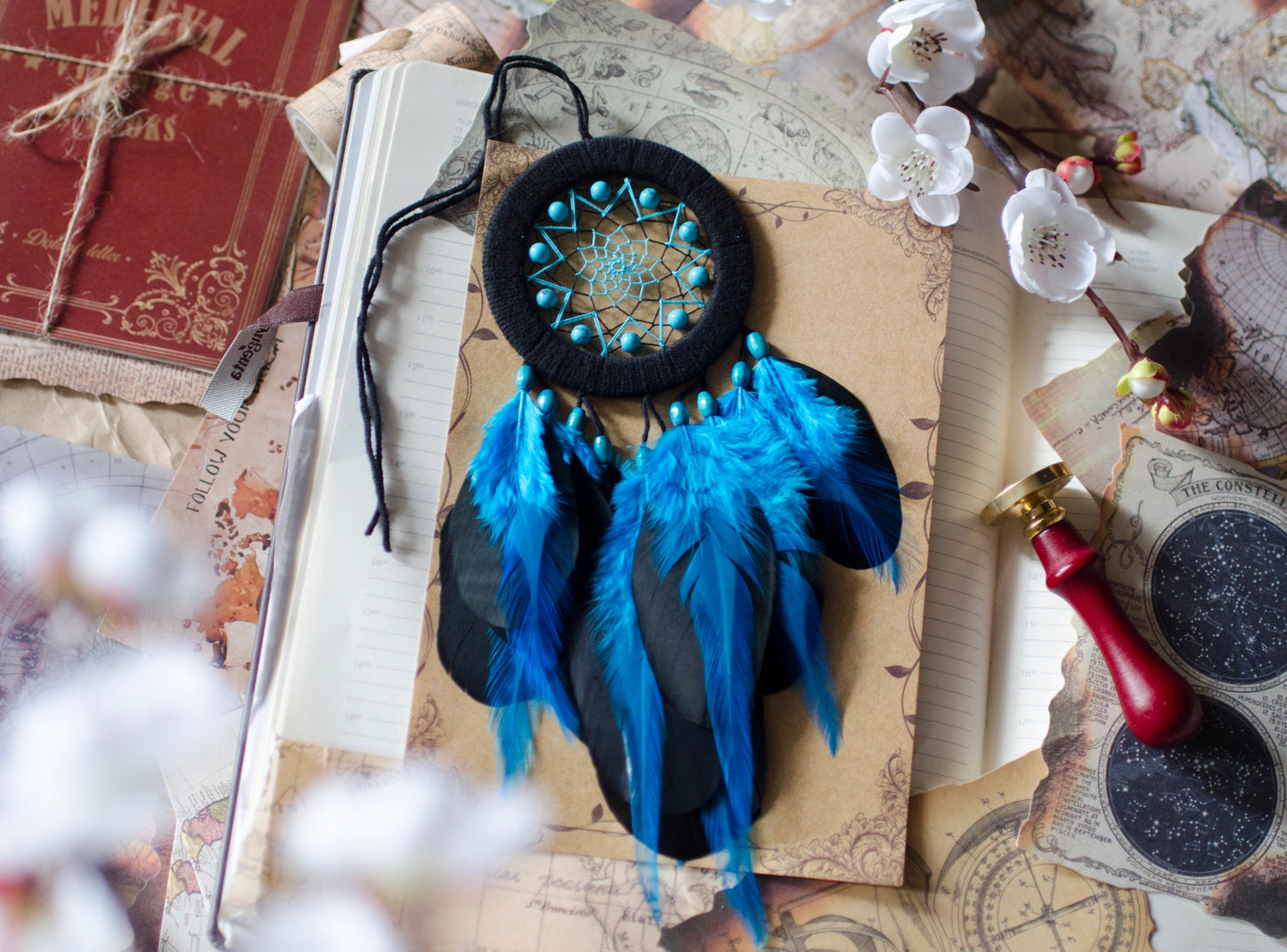 Small black and blue dreamcatcher with turquoise beads and feathers. Bold contrast and vibrant accents for compact spaces.