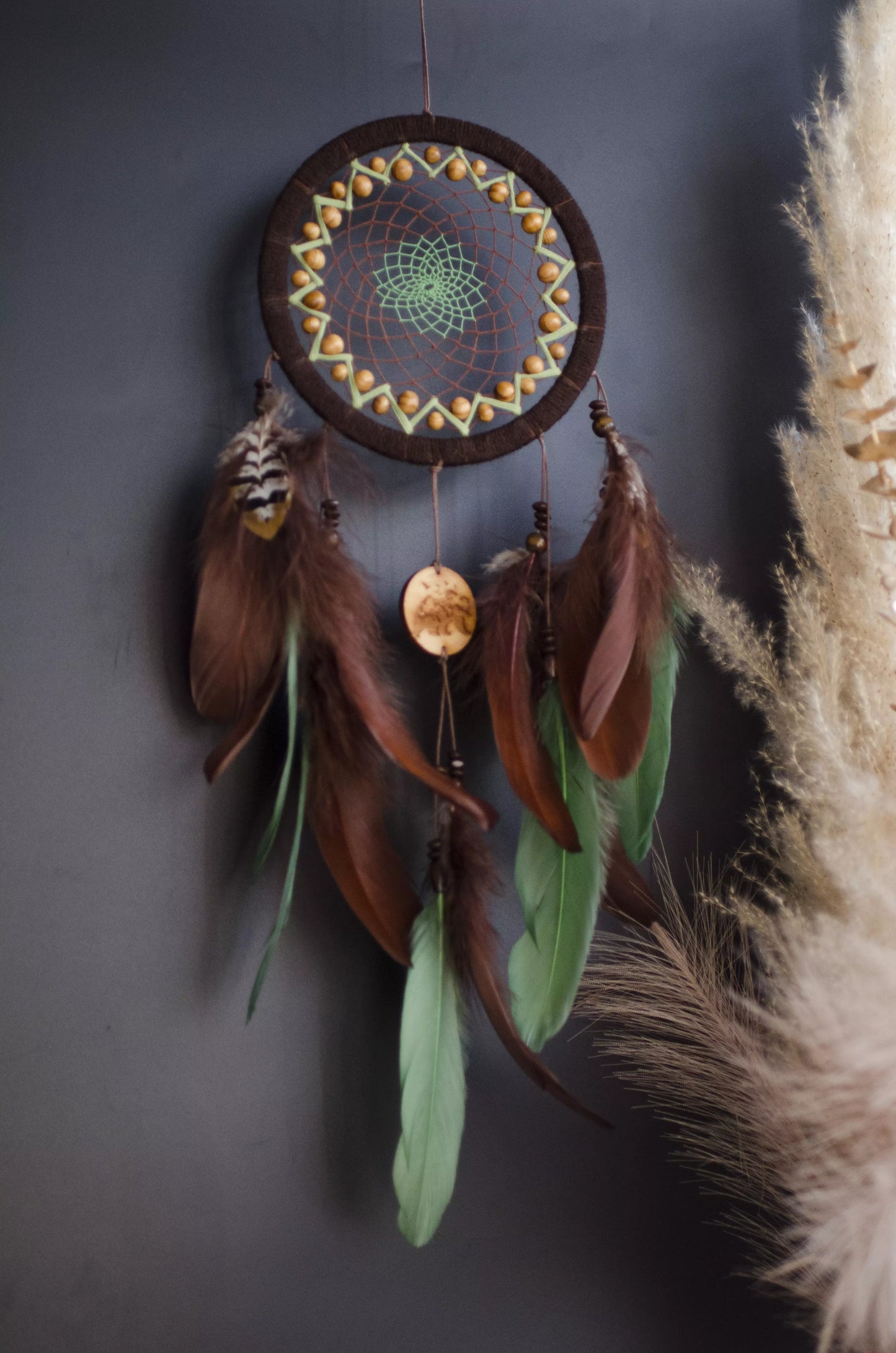 Handmade dream catcher with bear totem, rustic brown tones, feathers, and natural textures. Boho wall hanging for nature lovers and spiritual protection.