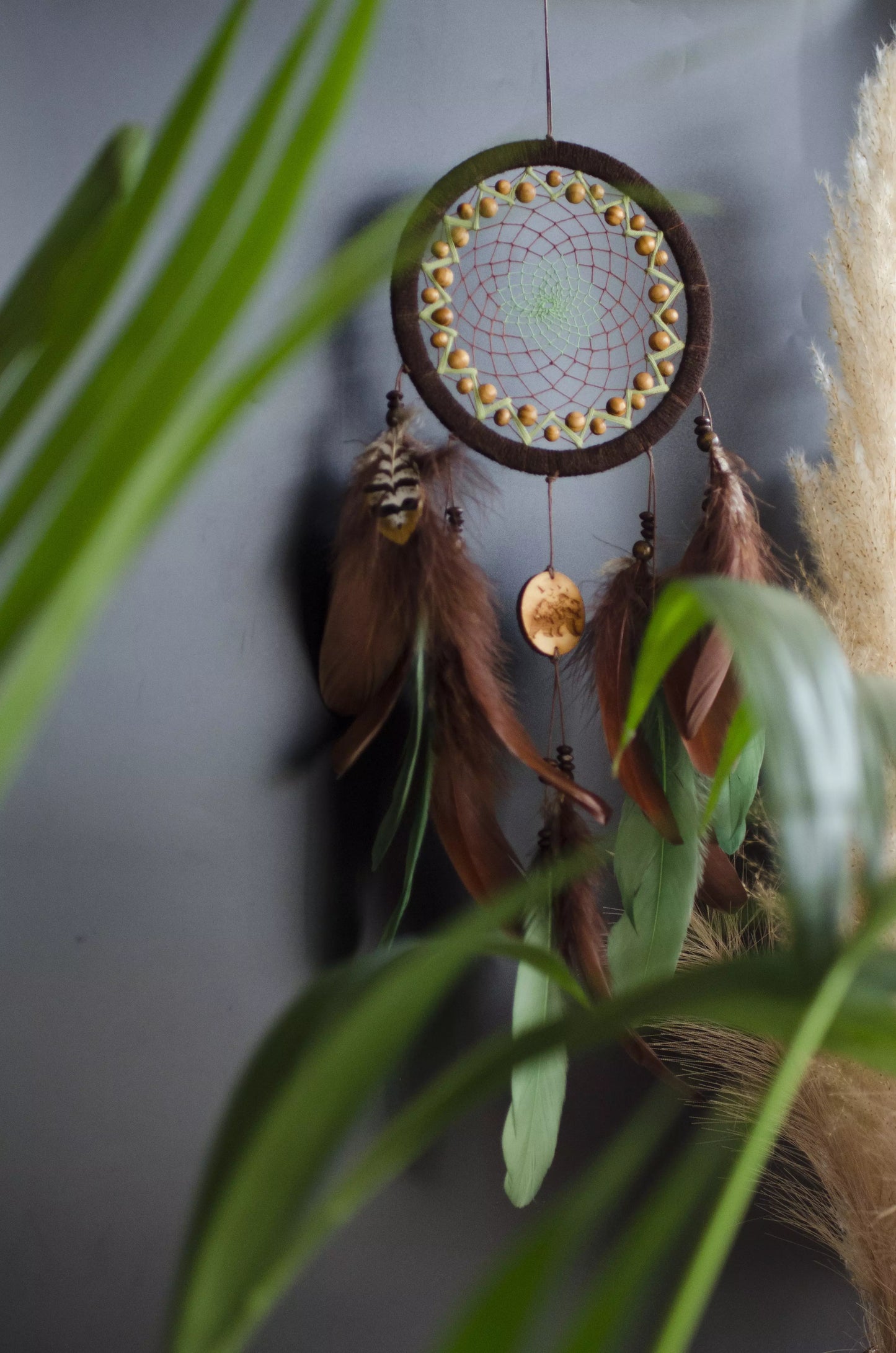 Handmade dream catcher with bear totem, rustic brown tones, feathers, and natural textures. Boho wall hanging for nature lovers and spiritual protection.