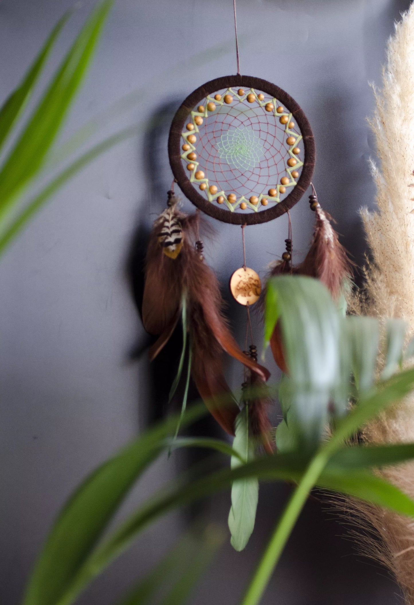 Handmade dream catcher with bear totem, rustic brown tones, feathers, and natural textures. Boho wall hanging for nature lovers and spiritual protection.