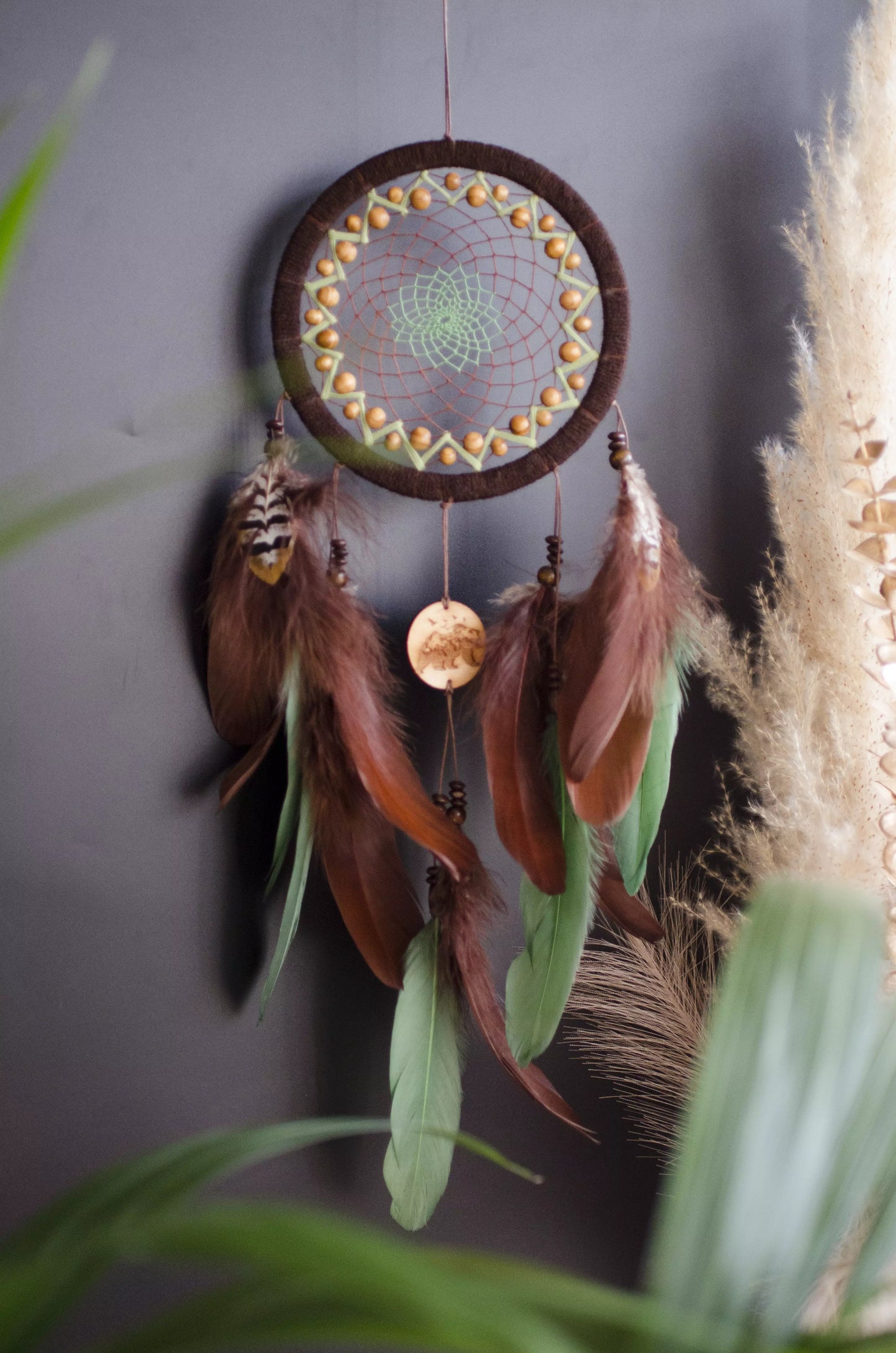 Handmade dream catcher with bear totem, rustic brown tones, feathers, and natural textures. Boho wall hanging for nature lovers and spiritual protection.