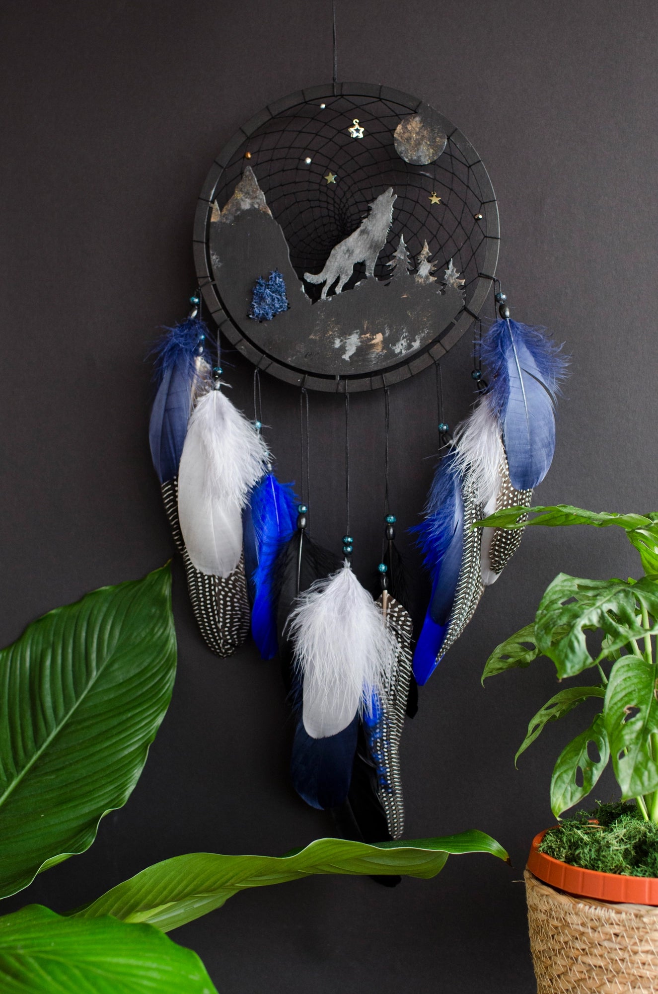 Handcrafted large black and blue wolf totem dreamcatcher with wooden wolf base, feathers, and webbing. Symbol of strength and guidance, perfect for nature-inspired spaces.