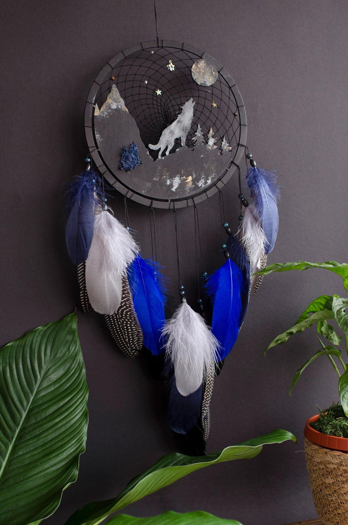 Handcrafted large black and blue wolf totem dreamcatcher with wooden wolf base, feathers, and webbing. Symbol of strength and guidance, perfect for nature-inspired spaces.