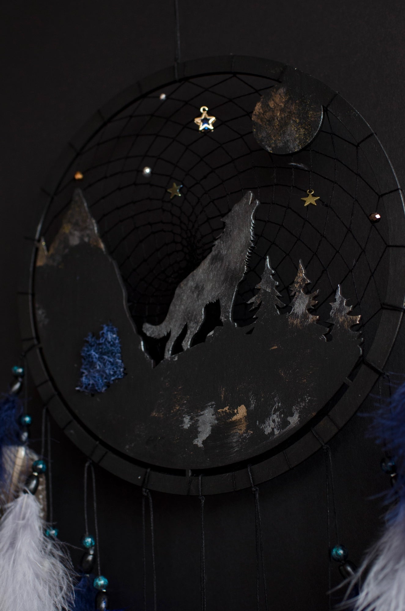 Handcrafted large black and blue wolf totem dreamcatcher with wooden wolf base, feathers, and webbing. Symbol of strength and guidance, perfect for nature-inspired spaces.