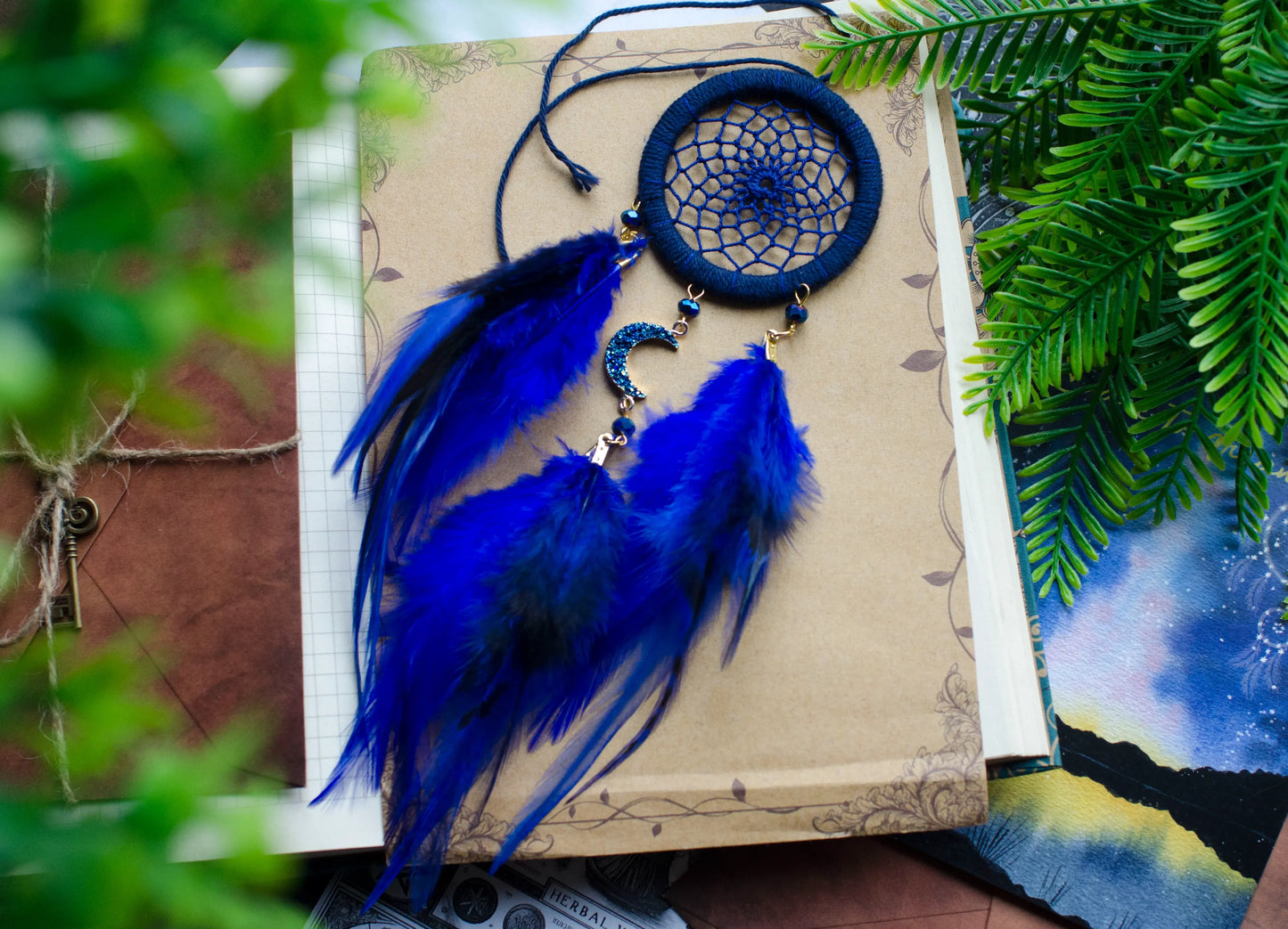 Small blue crescent moon dreamcatcher for car rearview mirror, with delicate feathers and celestial charm. Perfect for peaceful drives.