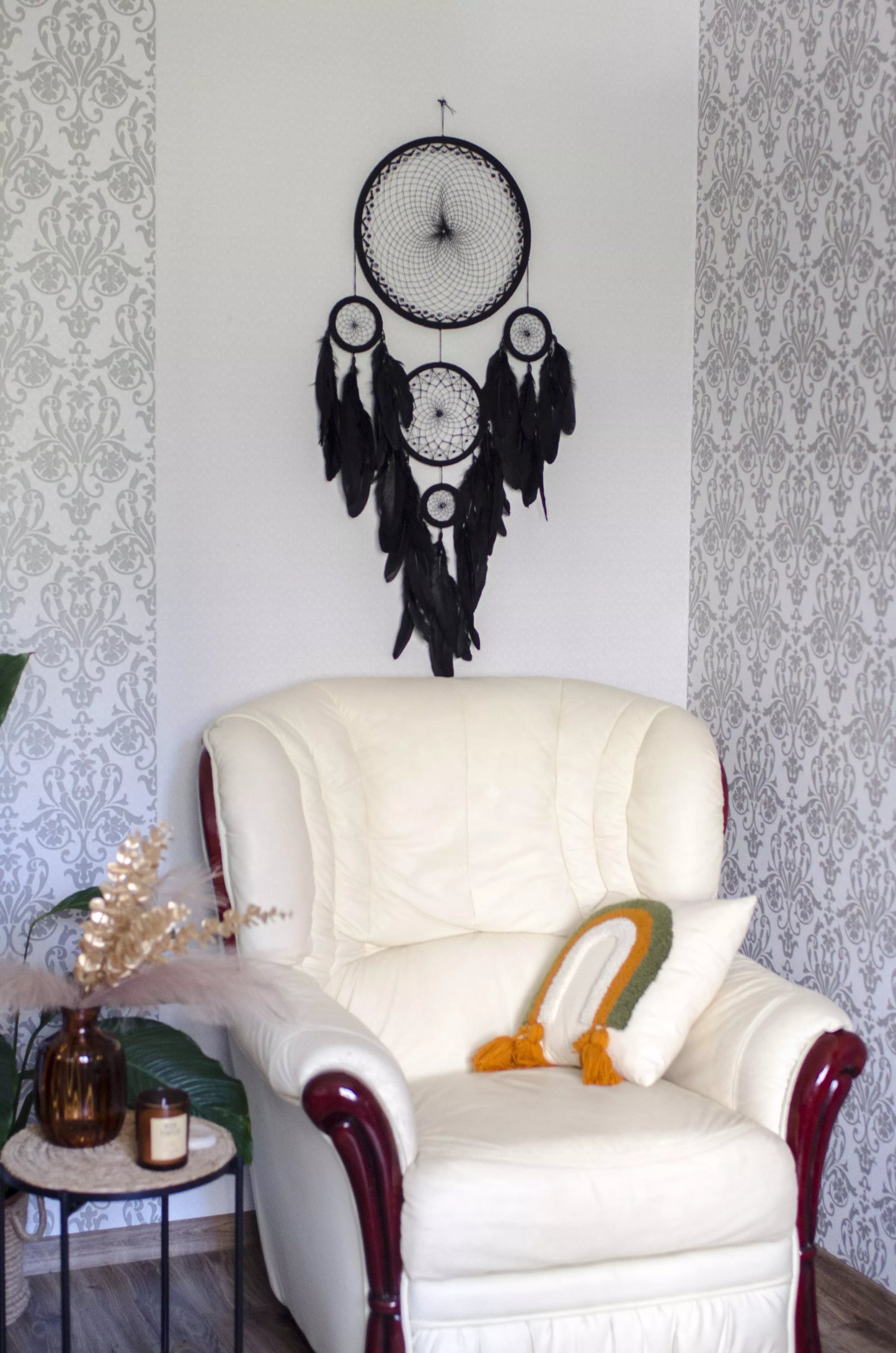 Large black multi-ring dreamcatcher featuring intricate woven web and cascading black feathers. Handcrafted boho and gothic wall decor, perfect for adding a statement piece to bedrooms or living rooms. Measures approximately 40 inches in height.