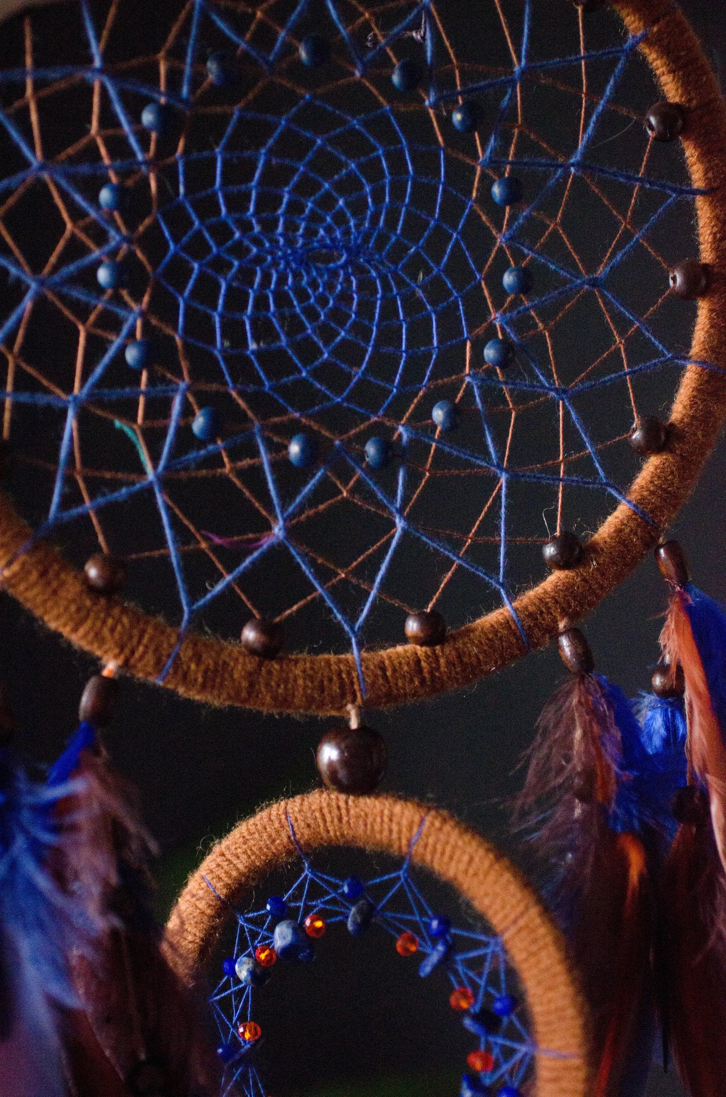 Large handmade dreamcatcher with blue and brown feathers, wooden hoops, and beaded web — boho wall hanging