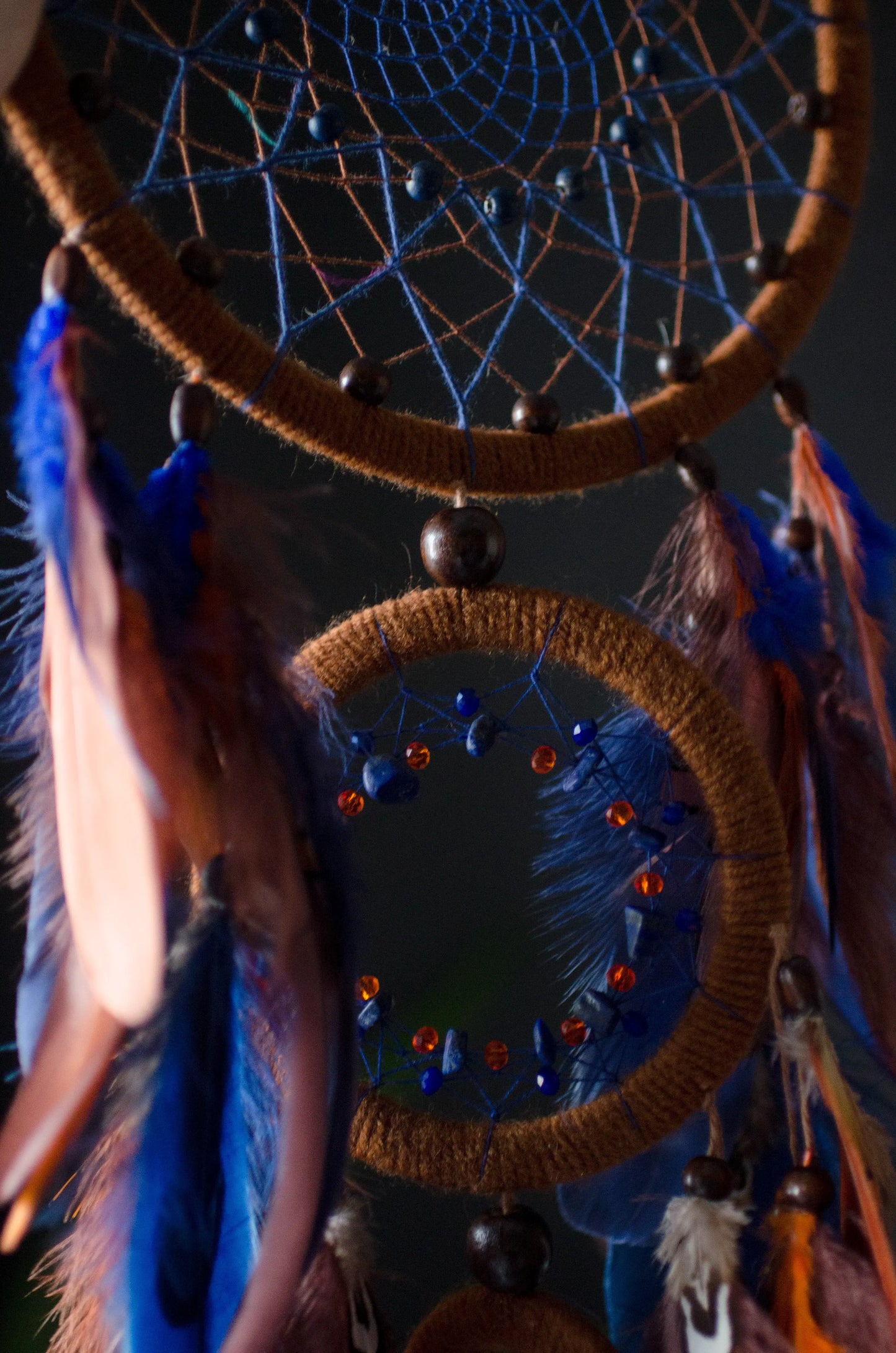 Large handmade dreamcatcher with blue and brown feathers, wooden hoops, and beaded web — boho wall hanging