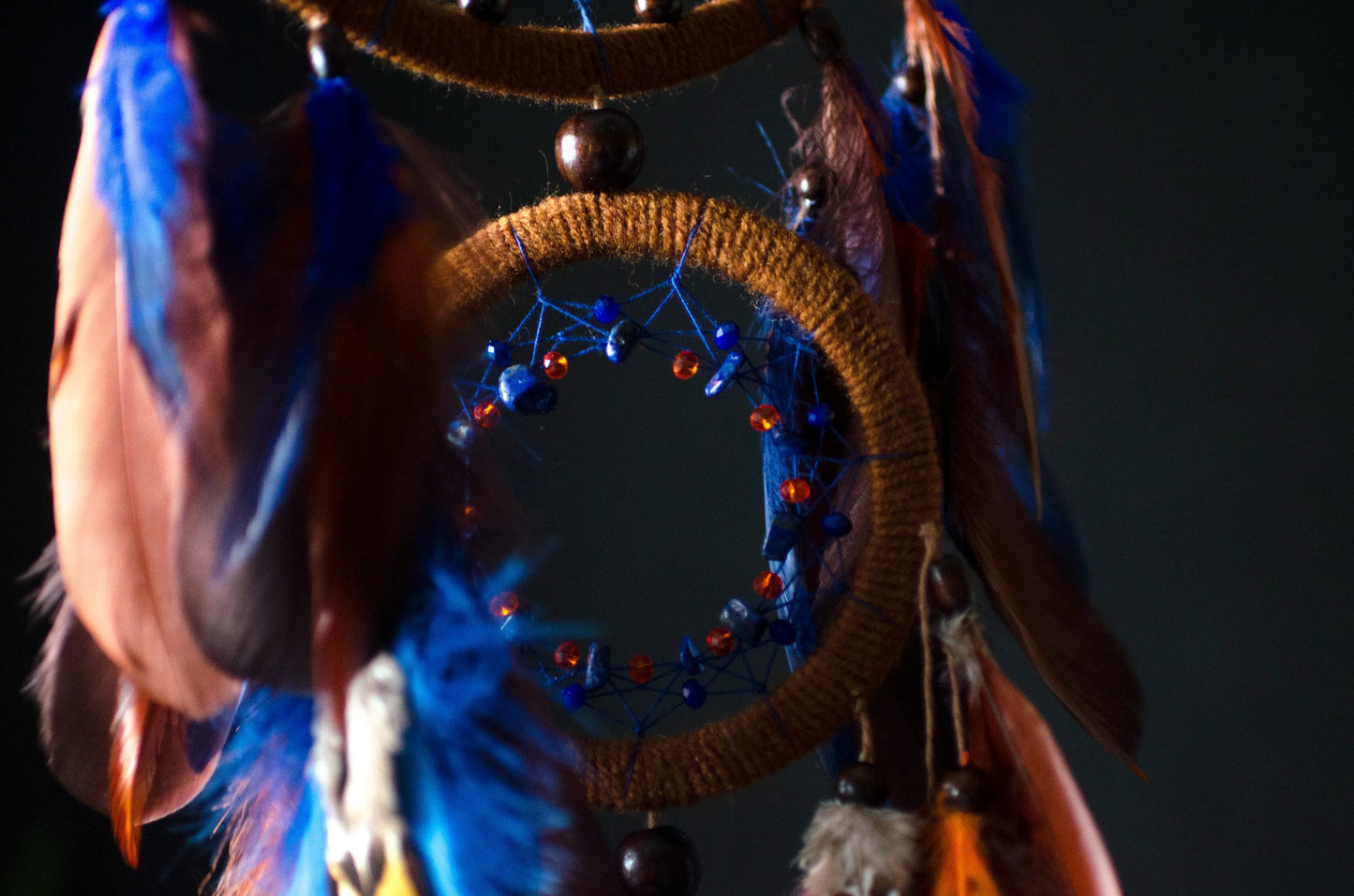 Large handmade dreamcatcher with blue and brown feathers, wooden hoops, and beaded web — boho wall hanging