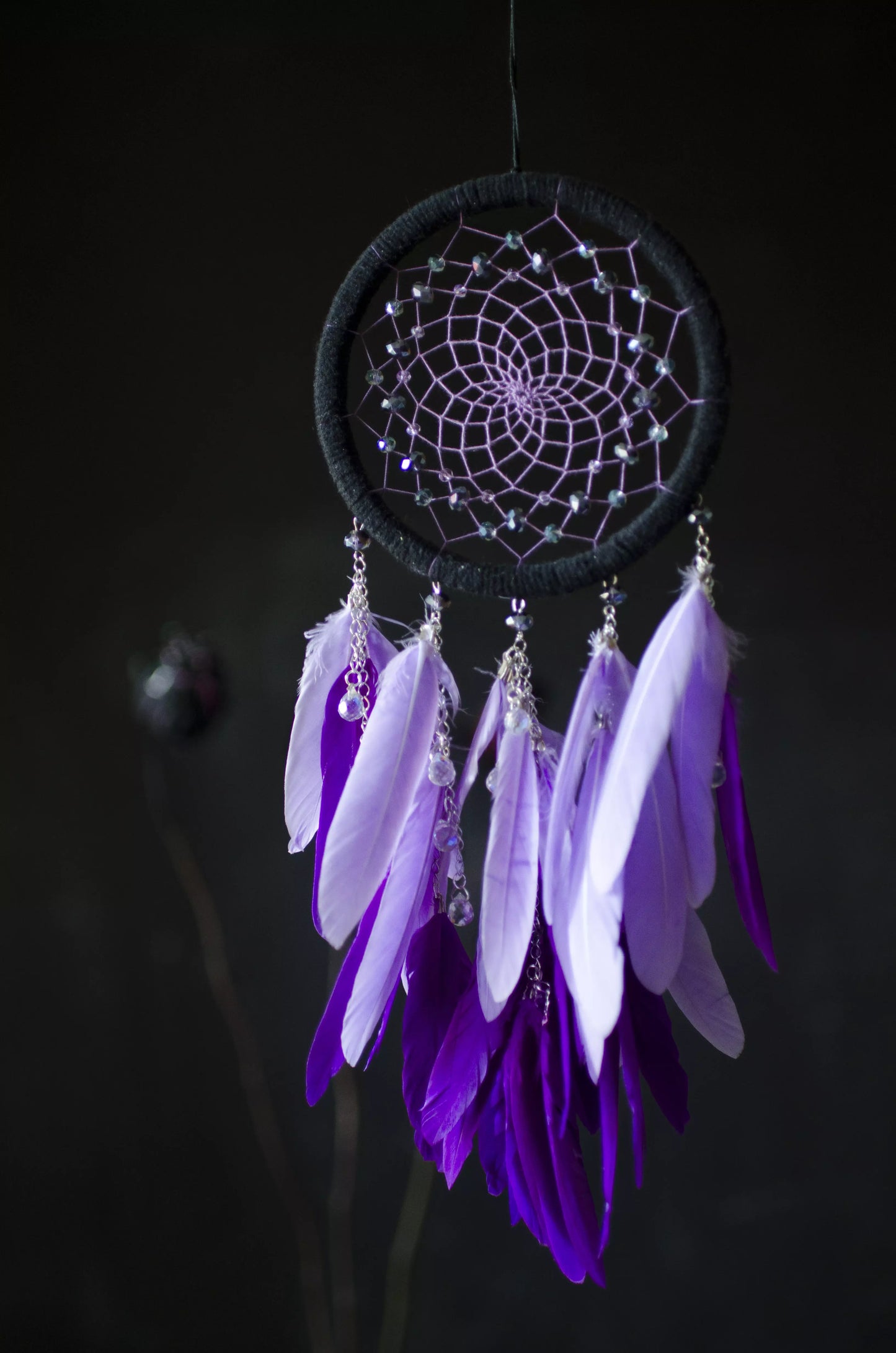 Handmade purple dreamcatcher with black hoop, purple feathers, and crystal beads. Boho wall decor for bedroom or living room, bringing peaceful and creative vibes.