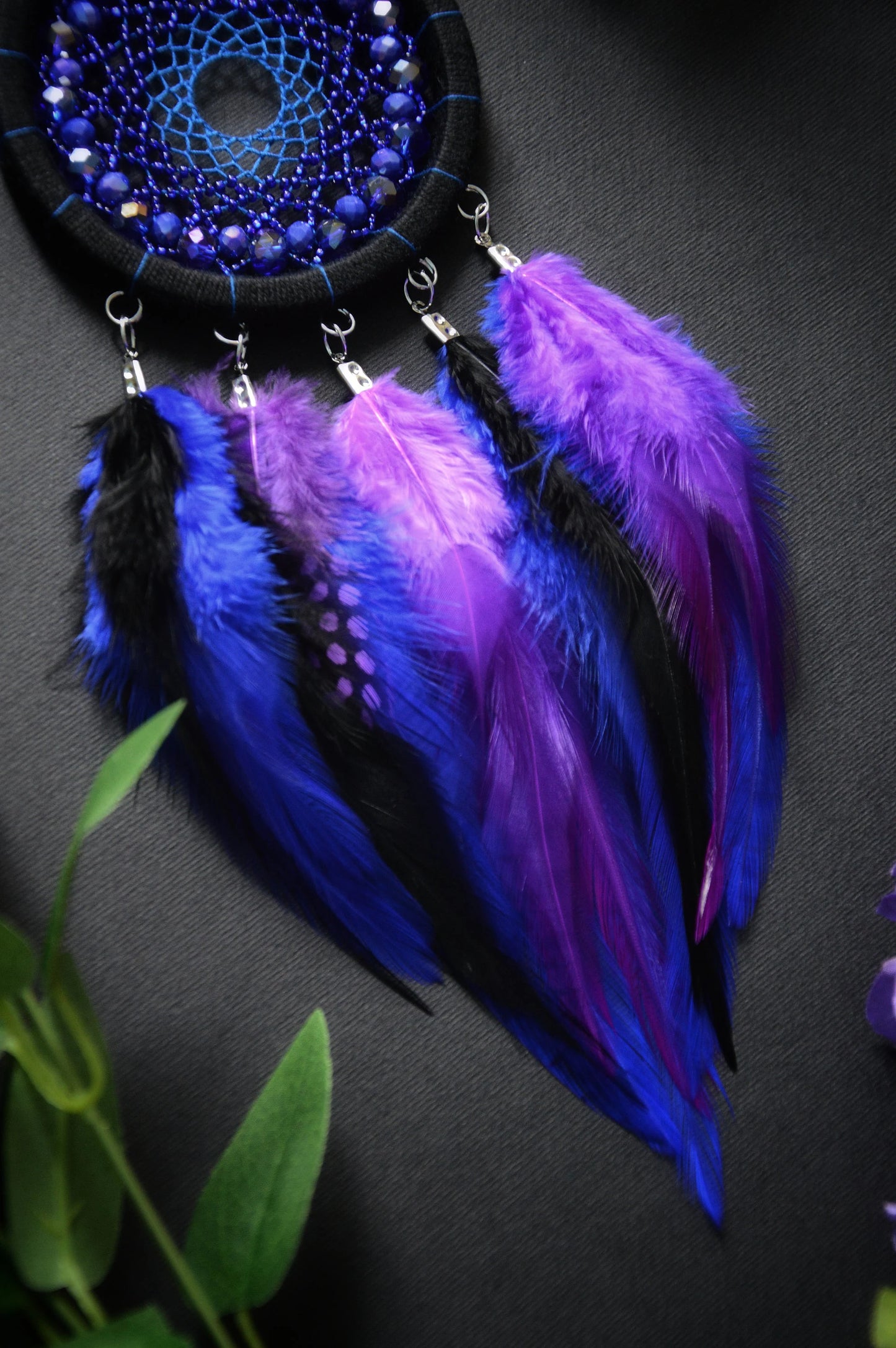 Handmade purple and blue dream catcher with intricate webbing, adorned with beads and vibrant purple and blue feathers, designed for boho wall decor and spiritual protection, perfect as a unique gift or a mystical home accent.