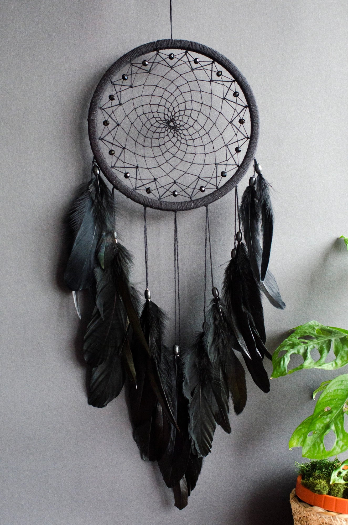 Handmade dreamcatcher with intricate web design, available in white or black, featuring hanging elements and two size options—standard and XL—perfect for boho or spiritual home decor.