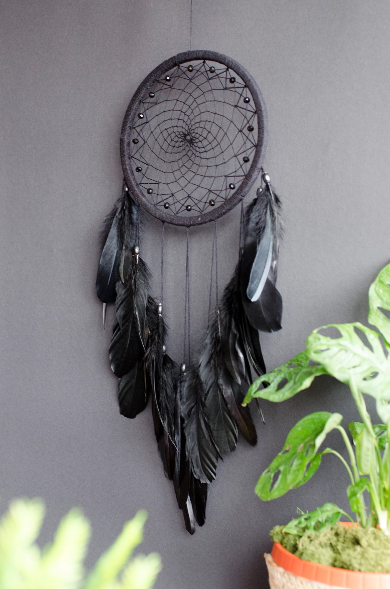Handmade dreamcatcher with intricate web design, available in white or black, featuring hanging elements and two size options—standard and XL—perfect for boho or spiritual home decor.