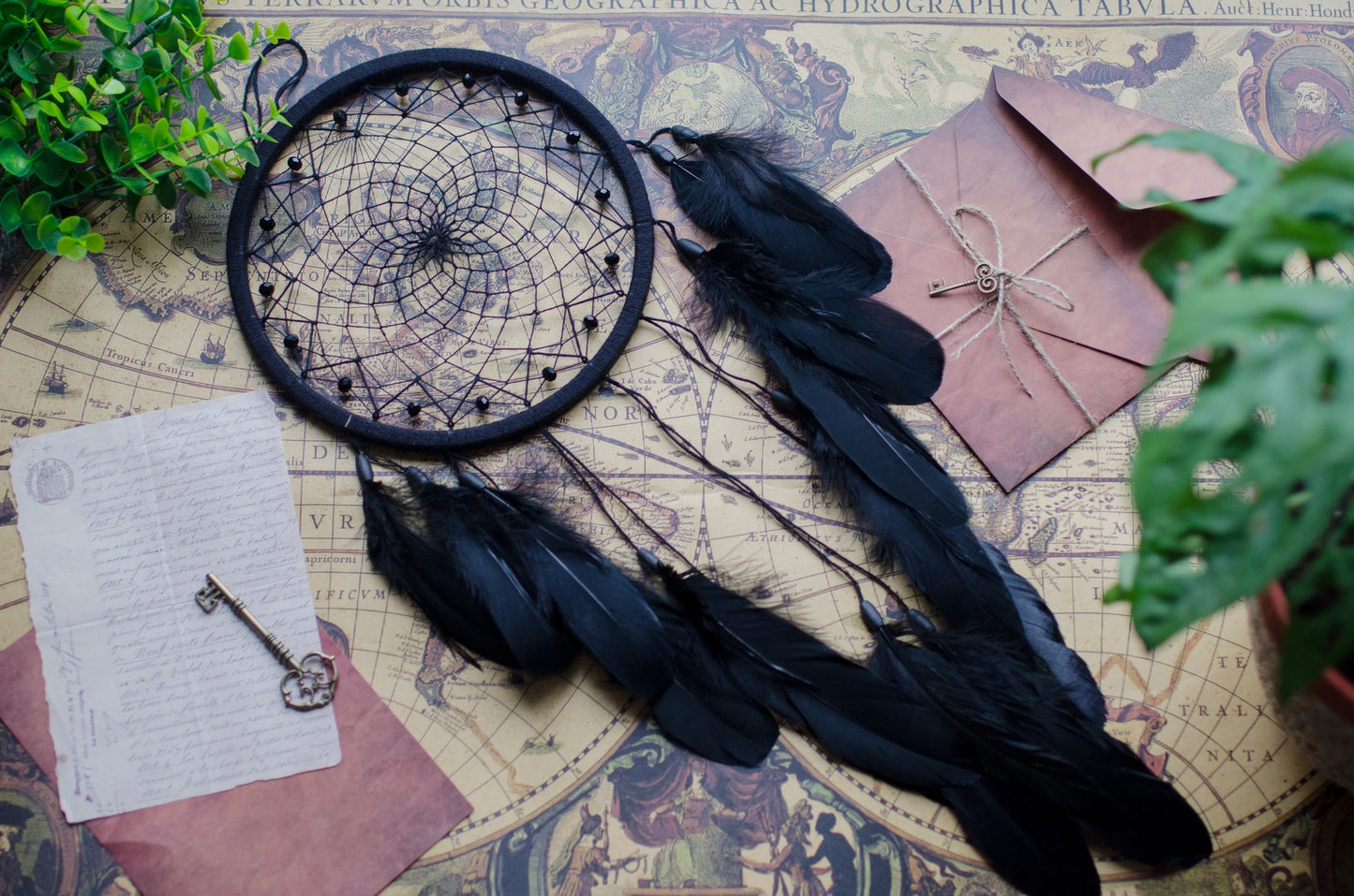 Handmade dreamcatcher with intricate web design, available in white or black, featuring hanging elements and two size options—standard and XL—perfect for boho or spiritual home decor.