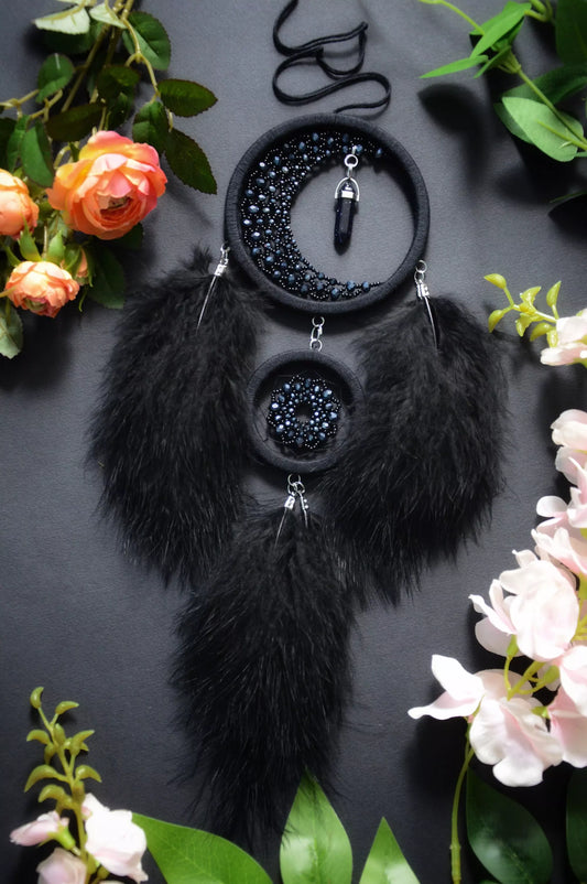 Handmade black crescent moon dreamcatcher adorned with black aventurine crystals, black beads, and soft black feathers, designed for boho and gothic decor, spiritual protection, and mystical ambiance in any space.