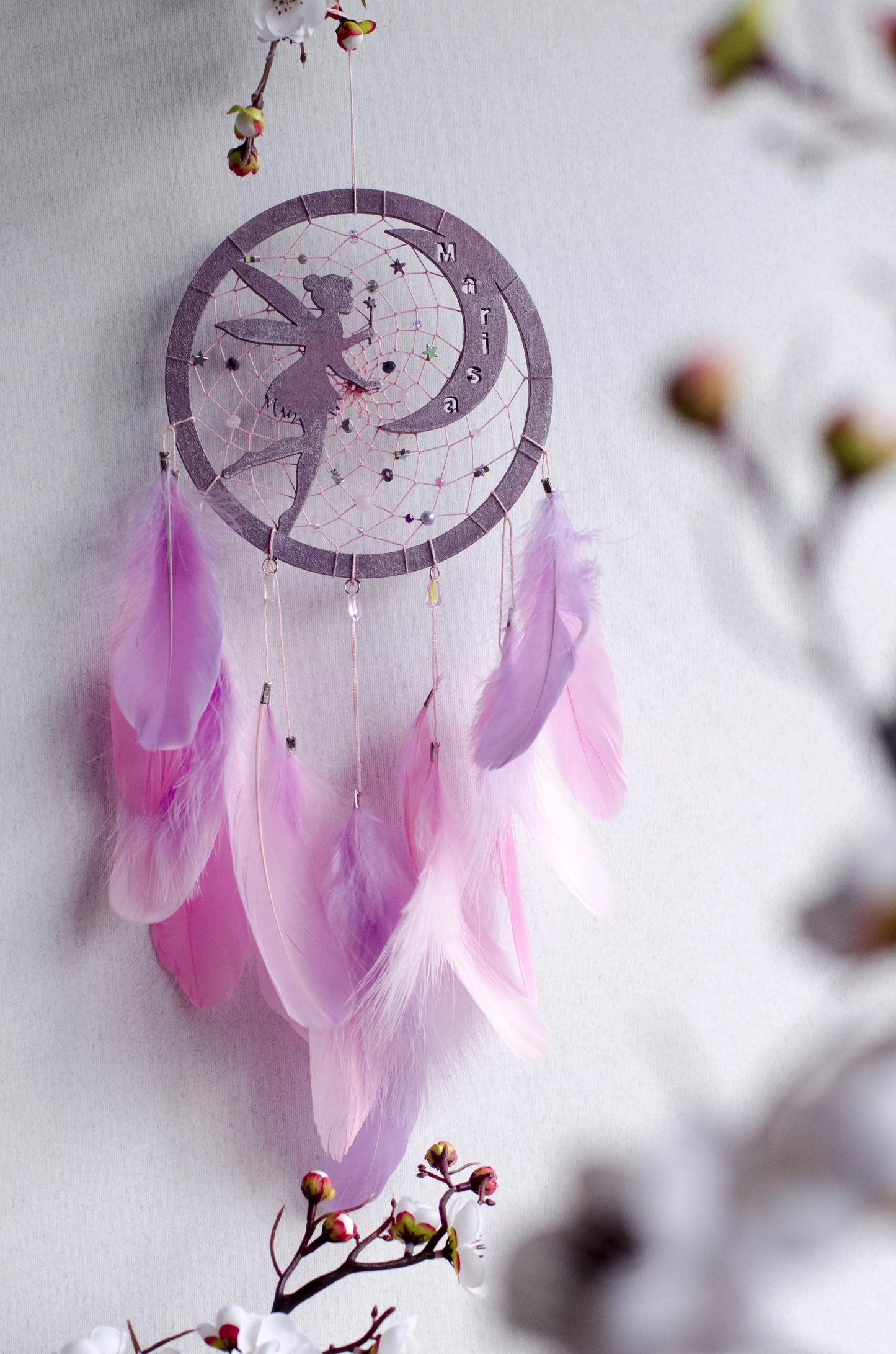 A personalized pink fairy-themed dreamcatcher with soft feathers and a custom name option. The delicate fairy design is woven into the web, making it a magical and unique wall decor piece for children's rooms or nurseries.