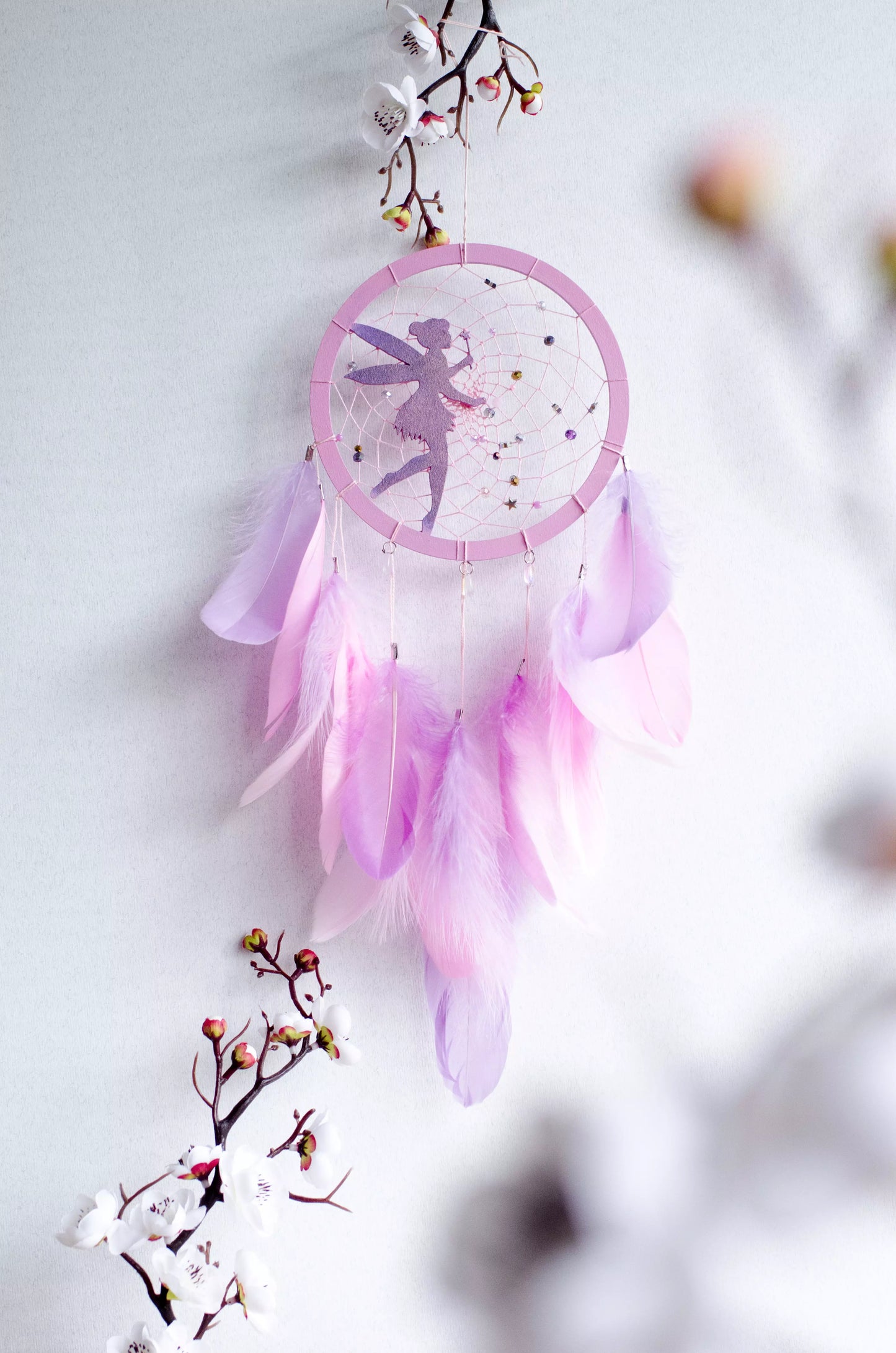 A personalized pink fairy-themed dreamcatcher with soft feathers and a custom name option. The delicate fairy design is woven into the web, making it a magical and unique wall decor piece for children's rooms or nurseries.