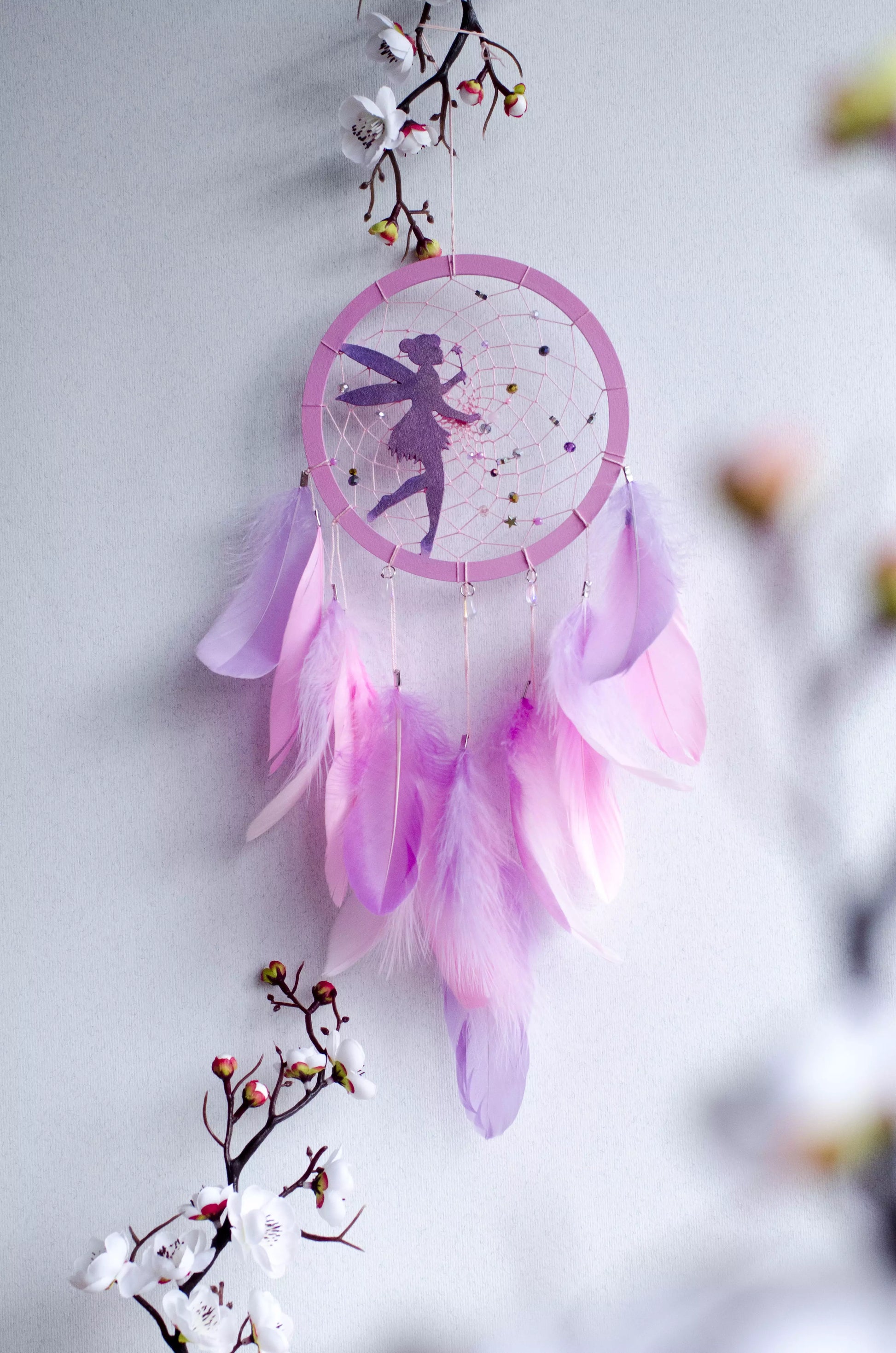 A personalized pink fairy-themed dreamcatcher with soft feathers and a custom name option. The delicate fairy design is woven into the web, making it a magical and unique wall decor piece for children's rooms or nurseries.