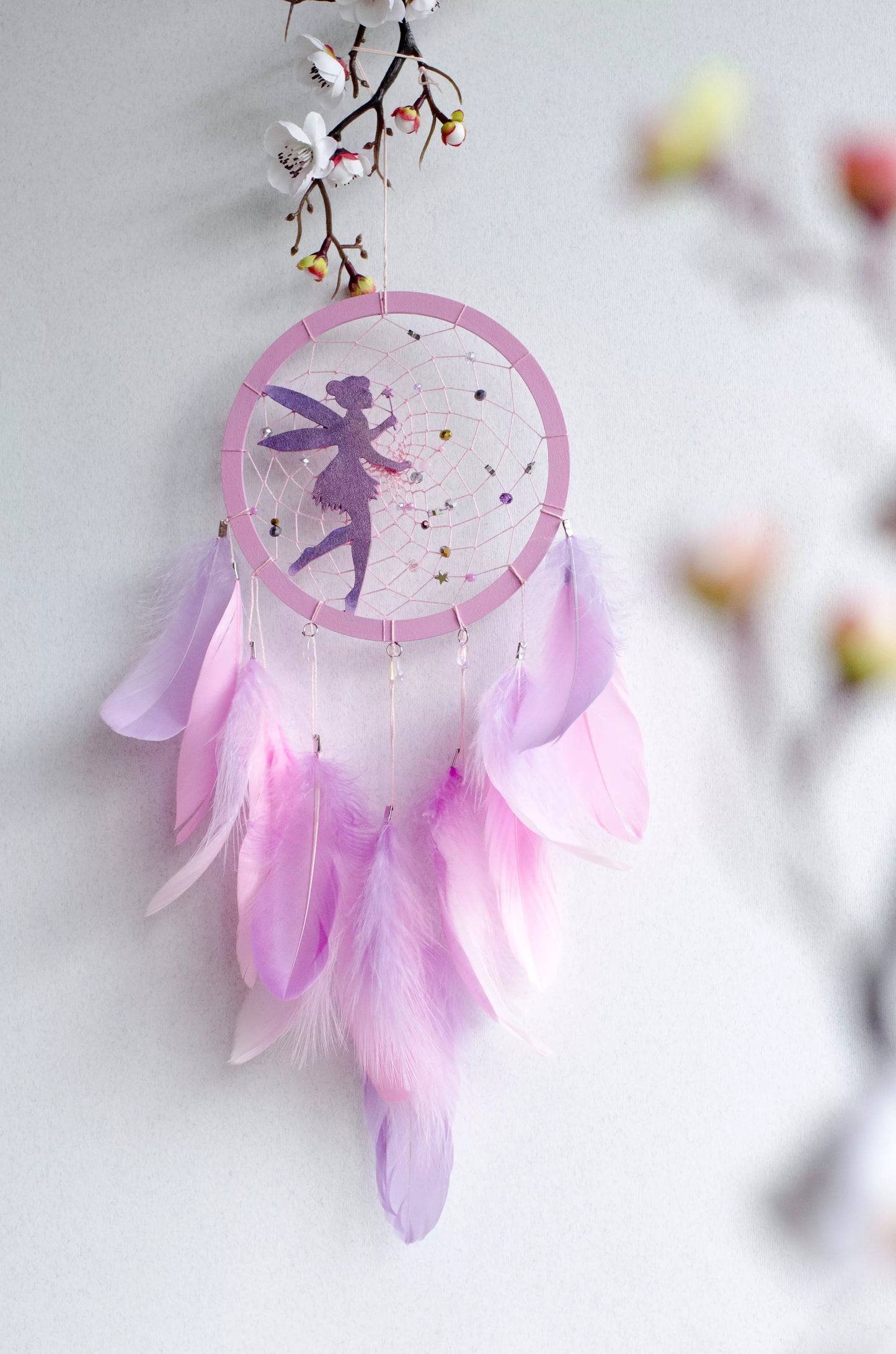 A personalized pink fairy-themed dreamcatcher with soft feathers and a custom name option. The delicate fairy design is woven into the web, making it a magical and unique wall decor piece for children's rooms or nurseries.