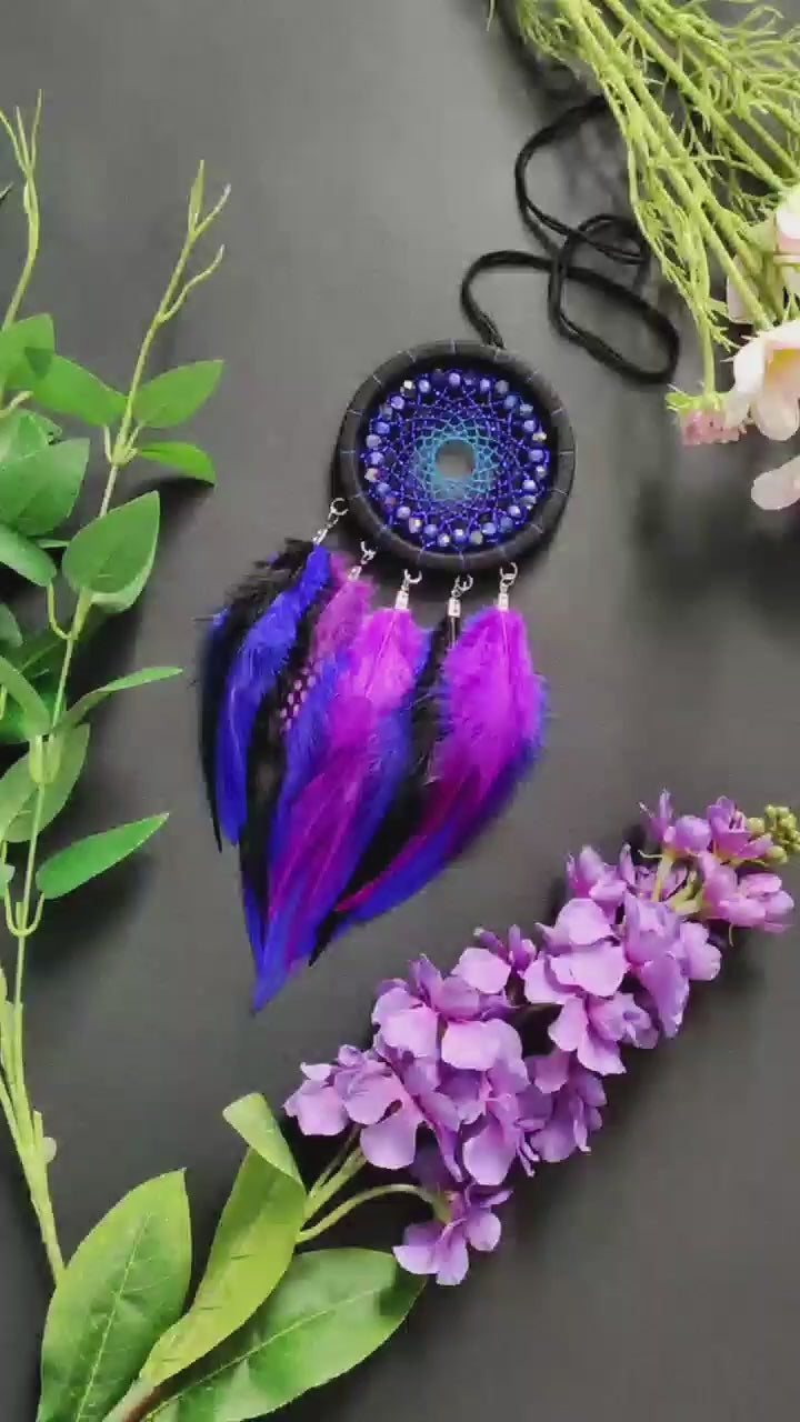 Handmade purple and blue dream catcher with intricate webbing, adorned with beads and vibrant purple and blue feathers, designed for boho wall decor and spiritual protection, perfect as a unique gift or a mystical home accent.