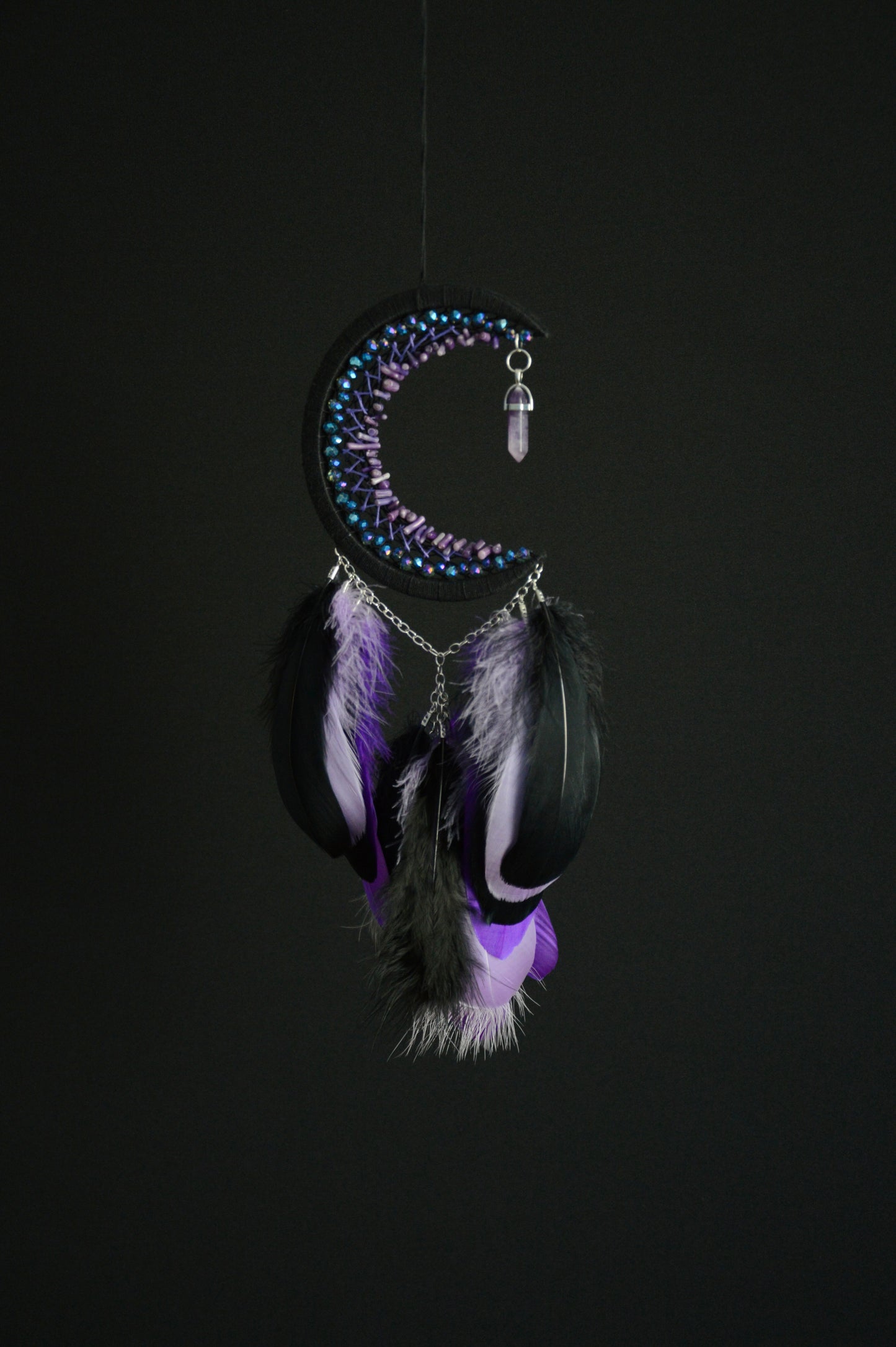 Handmade purple triple moon dreamcatcher set featuring intricate moon phase designs, adorned with purple and black feathers, amethyst crystal accents, and chain details. Perfect for celestial-inspired boho wall decor or spiritual meditation spaces.