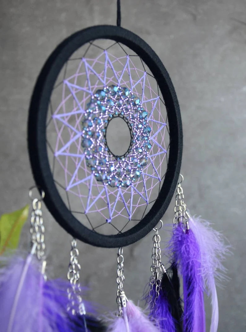 Handmade purple triple moon dreamcatcher set featuring intricate moon phase designs, adorned with purple and black feathers, amethyst crystal accents, and chain details. Perfect for celestial-inspired boho wall decor or spiritual meditation spaces.