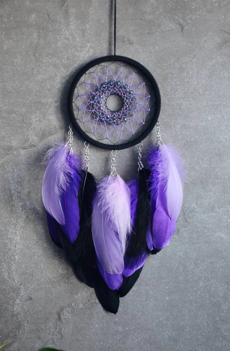 Handmade purple triple moon dreamcatcher set featuring intricate moon phase designs, adorned with purple and black feathers, amethyst crystal accents, and chain details. Perfect for celestial-inspired boho wall decor or spiritual meditation spaces.