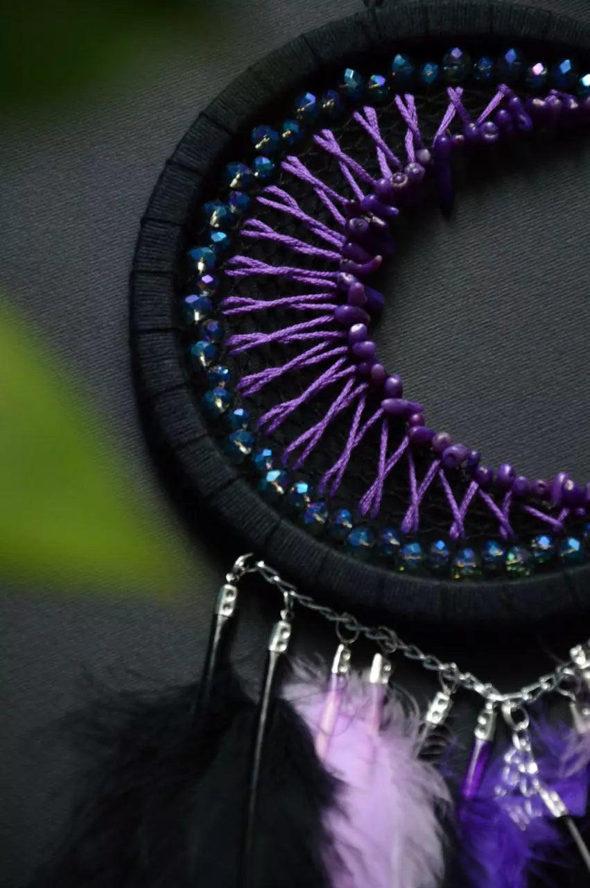 Handmade purple triple moon dreamcatcher set featuring intricate moon phase designs, adorned with purple and black feathers, amethyst crystal accents, and chain details. Perfect for celestial-inspired boho wall decor or spiritual meditation spaces.